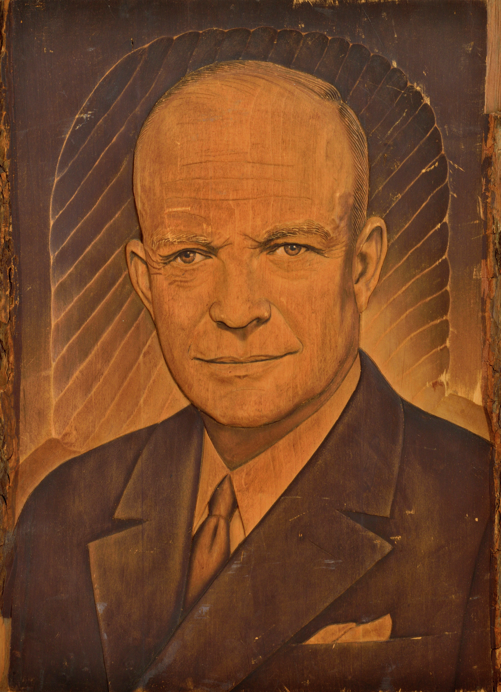 Carved and painted wooden carved head and shoulder portrait depicting Dwight Eisenhower as if in an photograph with some black paint