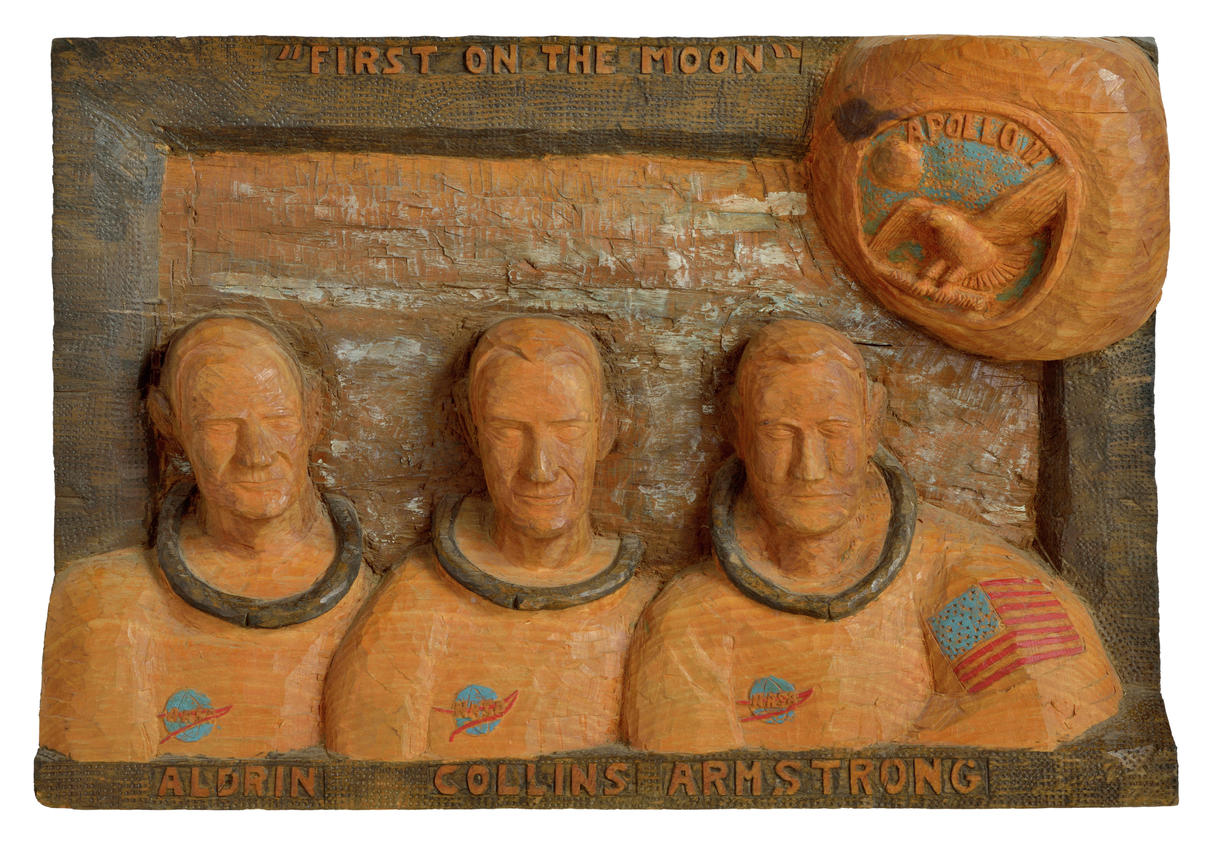 American polychrome relief carved wooden plaque depicting head and shoulder portraits of the Apollo 11 astronauts, Neil Armstrong, Buzz Aldrin, Michael Collins, inscribed First on the Moon